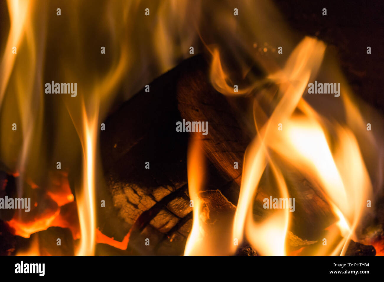 A log surrounded with flames on a coal fire Stock Photo Alamy