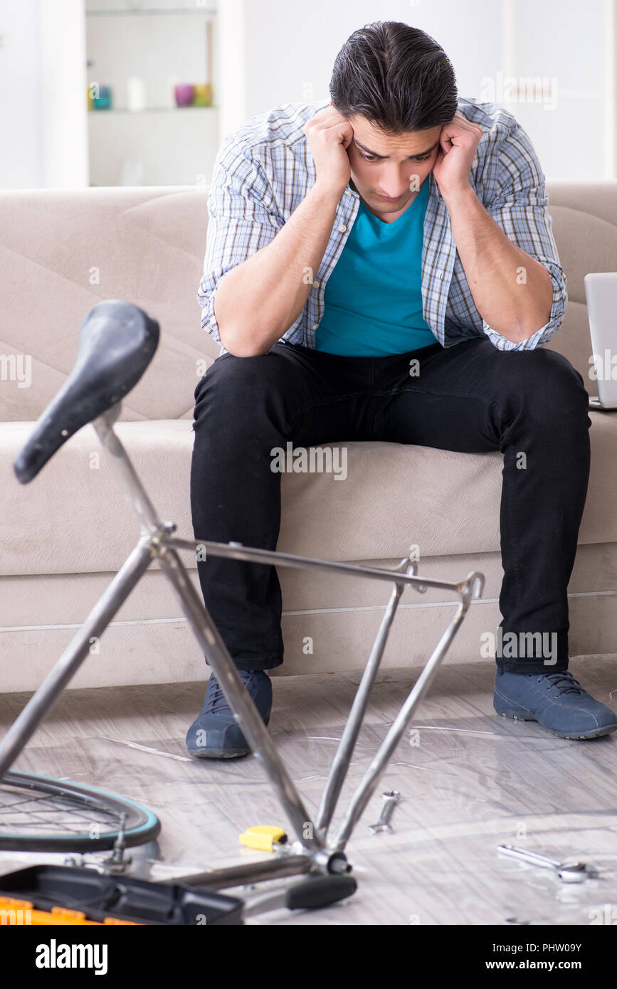 Young man repairing bicycle at home Stock Photo - Alamy