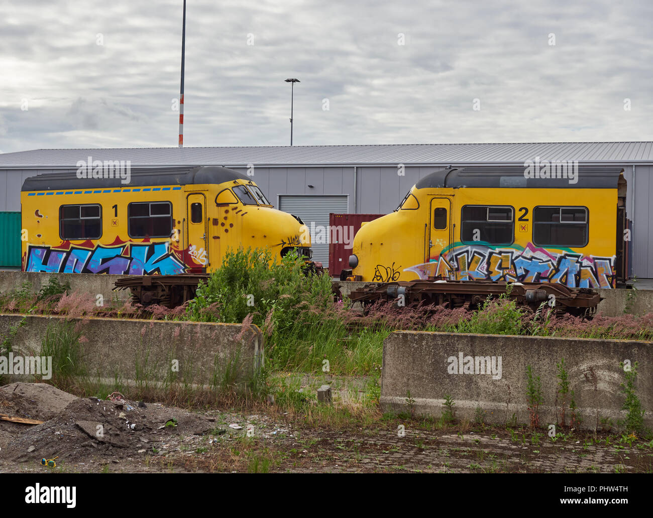 A pair of Old Dutch urban Commuter Train Drivers Cabins parked on the Quayside at Den Haag Container Port, partially recycled for parts and awaiting f Stock Photo