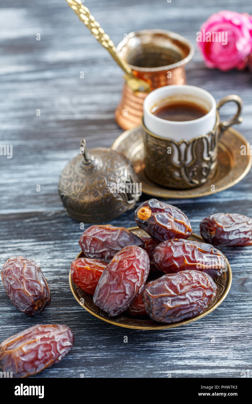 Dates on the plate, copper cezve and black coffee. Stock Photo