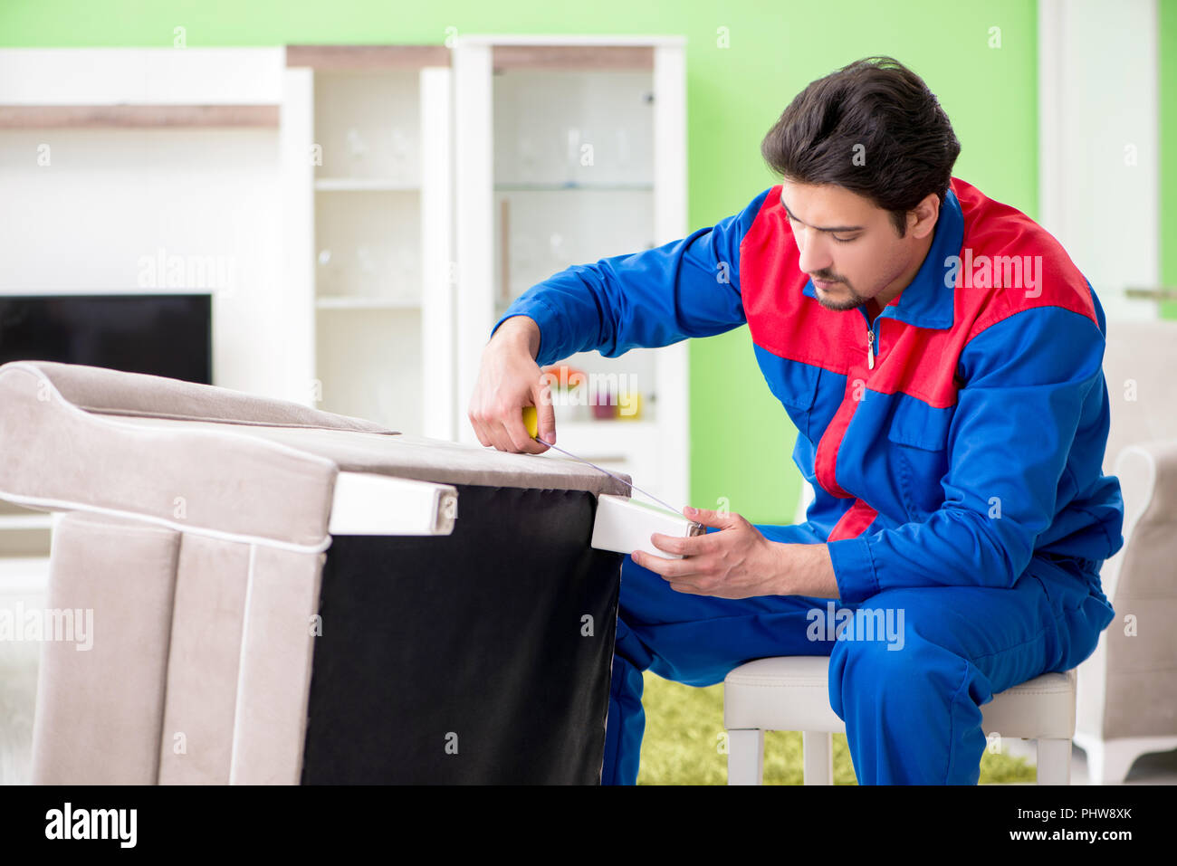 Repair contractor repairing broken furniture at home Stock Photo Alamy