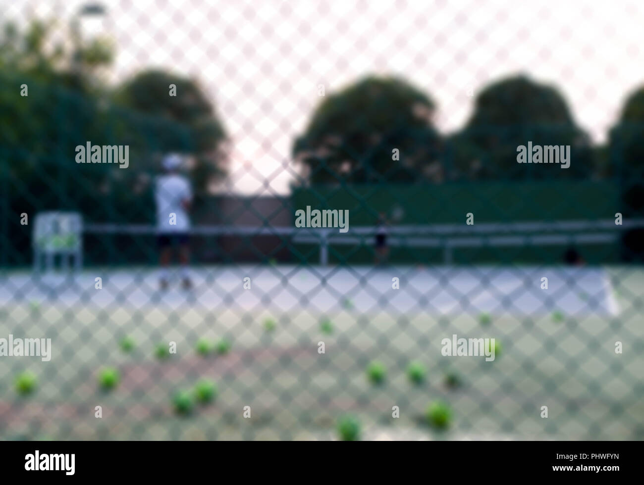 Blurred concept Tennis Instructor Teaching His Student how to play tennis on court Stock Photo