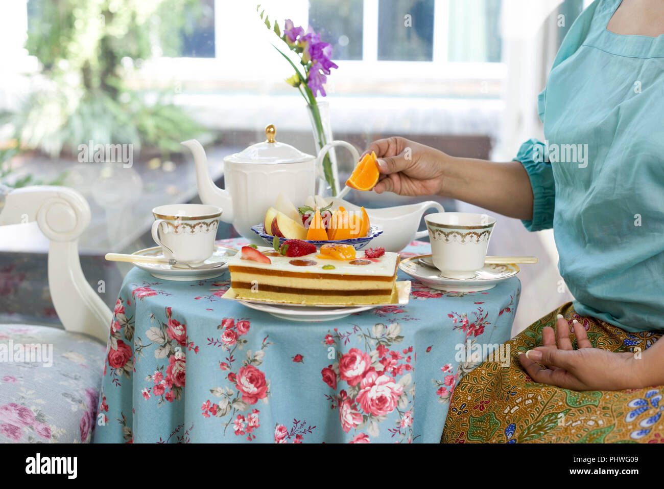 Asian  woman having  tea and cake and fresh fruit Stock Photo