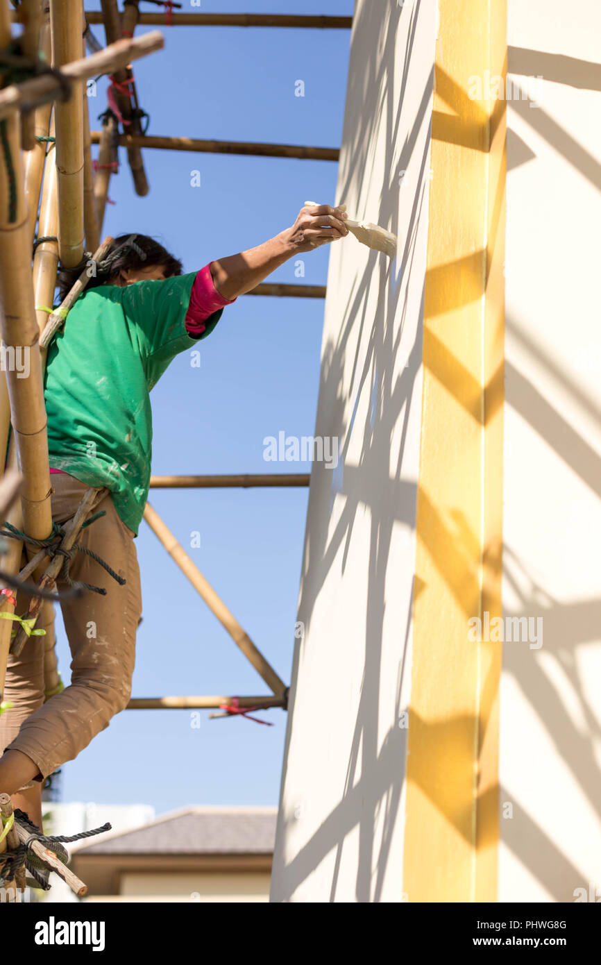 Painter on wooden scaffold painting Exterior House Stock Photo - Alamy