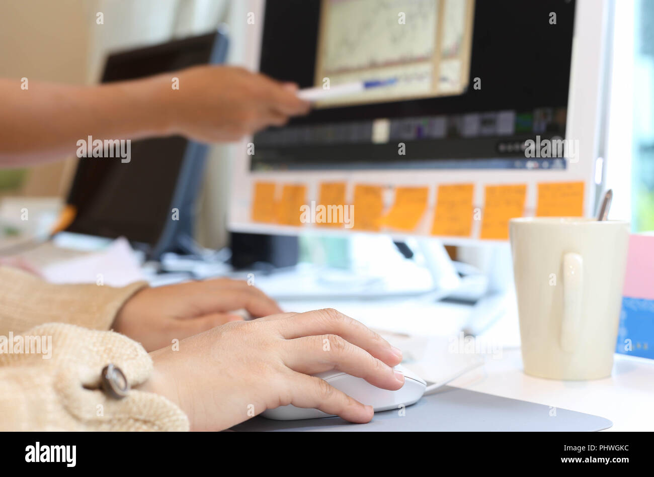 women in office working together on desktop Stock Photo