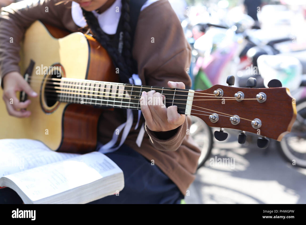 Teenage school girl playing an acoustic guitar Stock Photo - Alamy