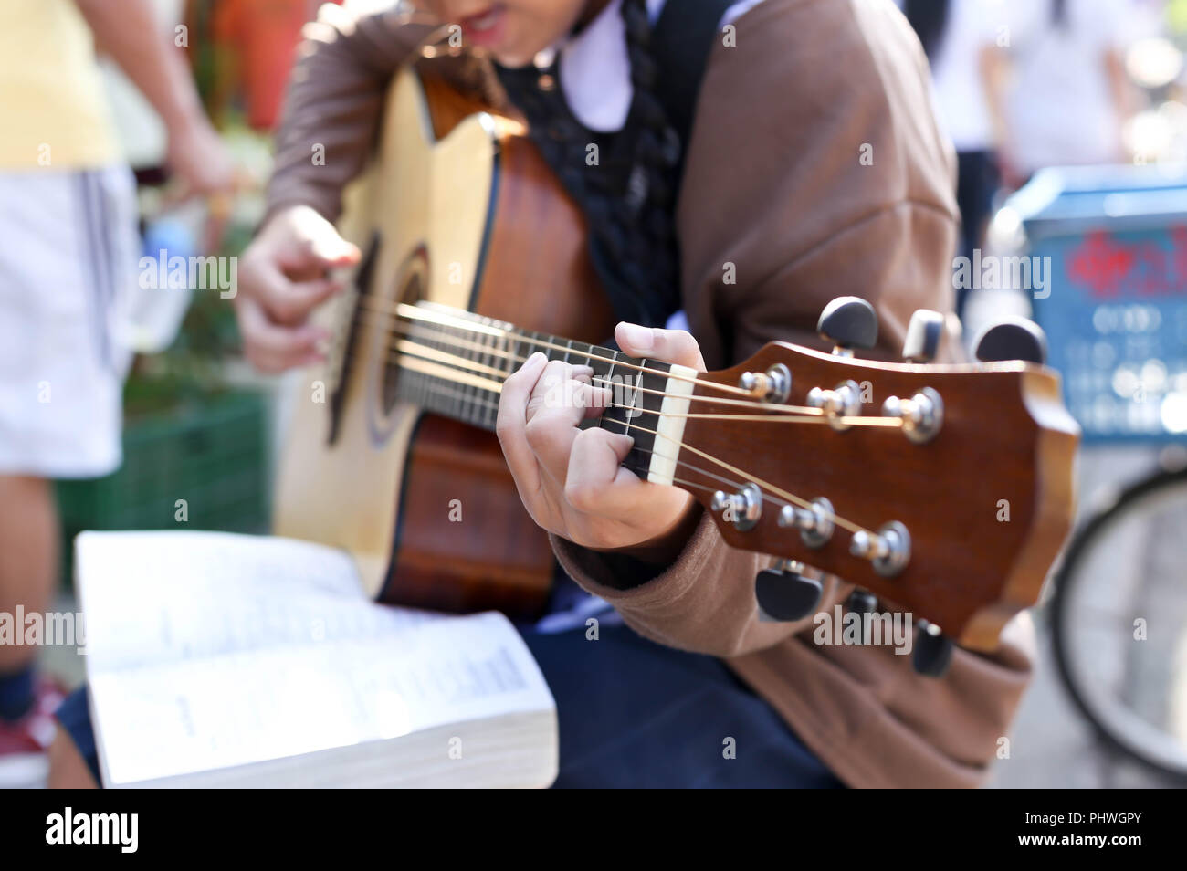 Teenage school girl playing an acoustic guitar Stock Photo - Alamy