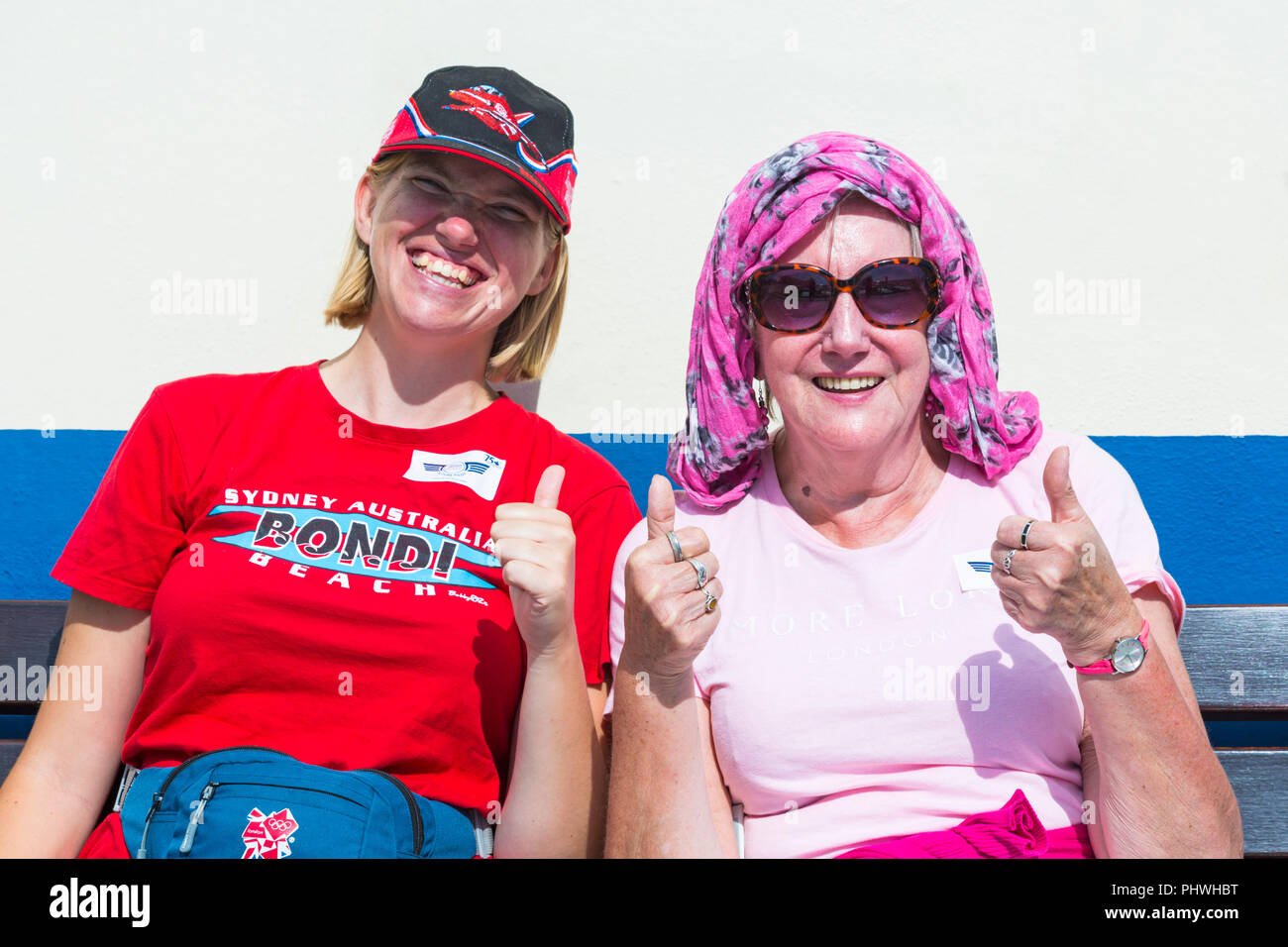 Two smiling women sitting on Bournemouth Pier giving Bournemouth the thumbs up on a hot sunny day at Bournemouth, Dorset UK in September Stock Photo