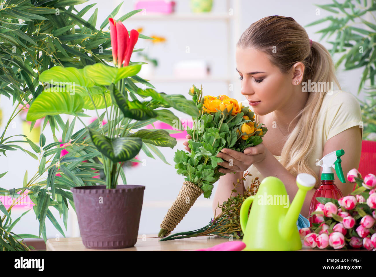 Young woman watering plants in her garden Stock Photo - Alamy