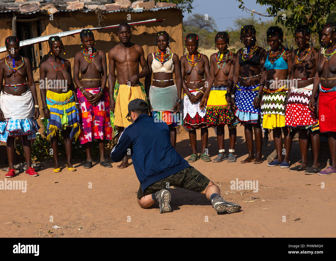 European tourist filming mudimba tribe women in traditional 