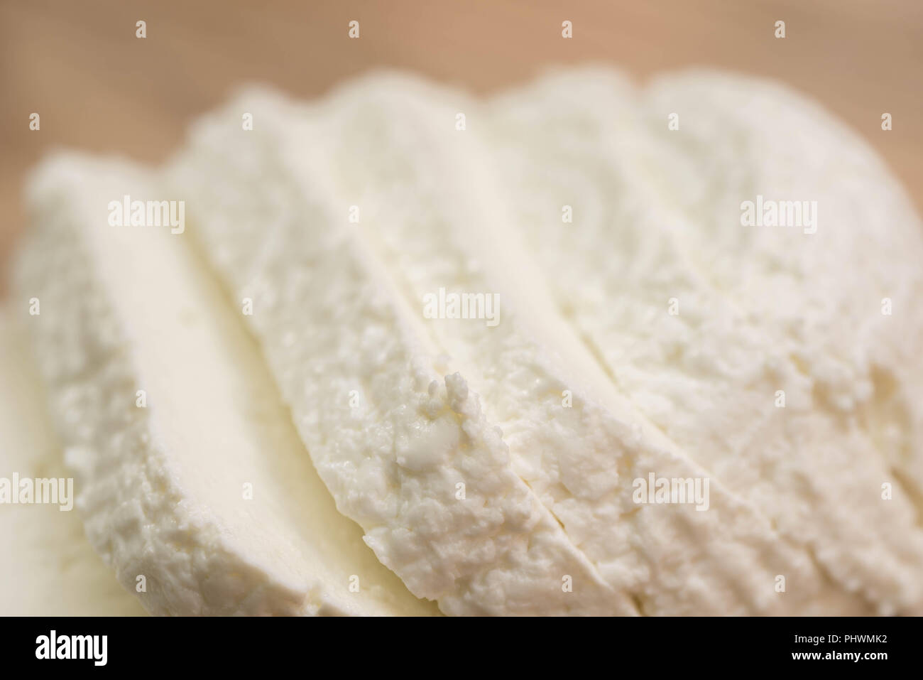 sliced  white cottage cheese on wooden cutting board  macron Stock Photo