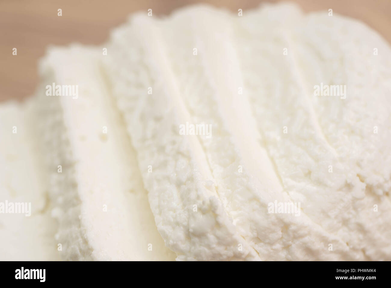 sliced  white cottage cheese on wooden cutting board  macron Stock Photo