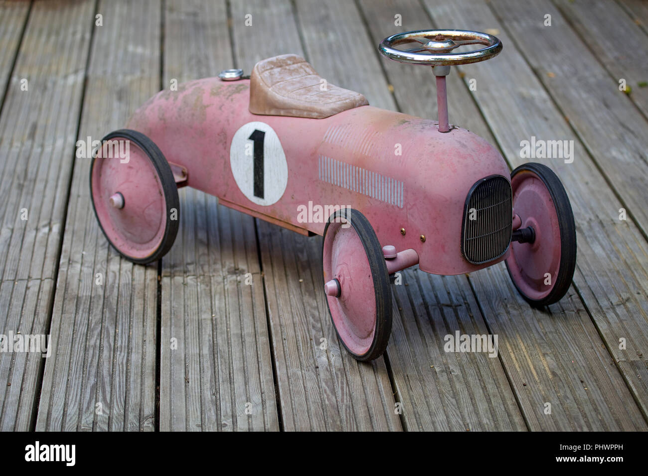 Childs old metal toy car on decking Stock Photo
