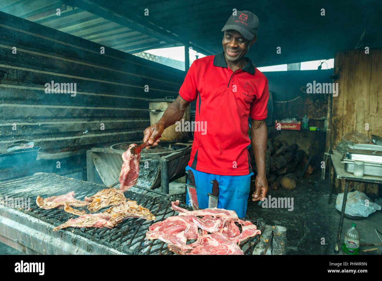 A local Zimbabwean prepares food in a traditional restaurant in Harare. Stock Photo