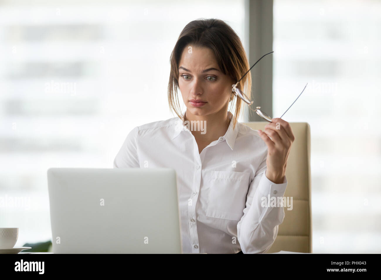 Shocked surprised businesswoman amazed by reading online news on Stock Photo