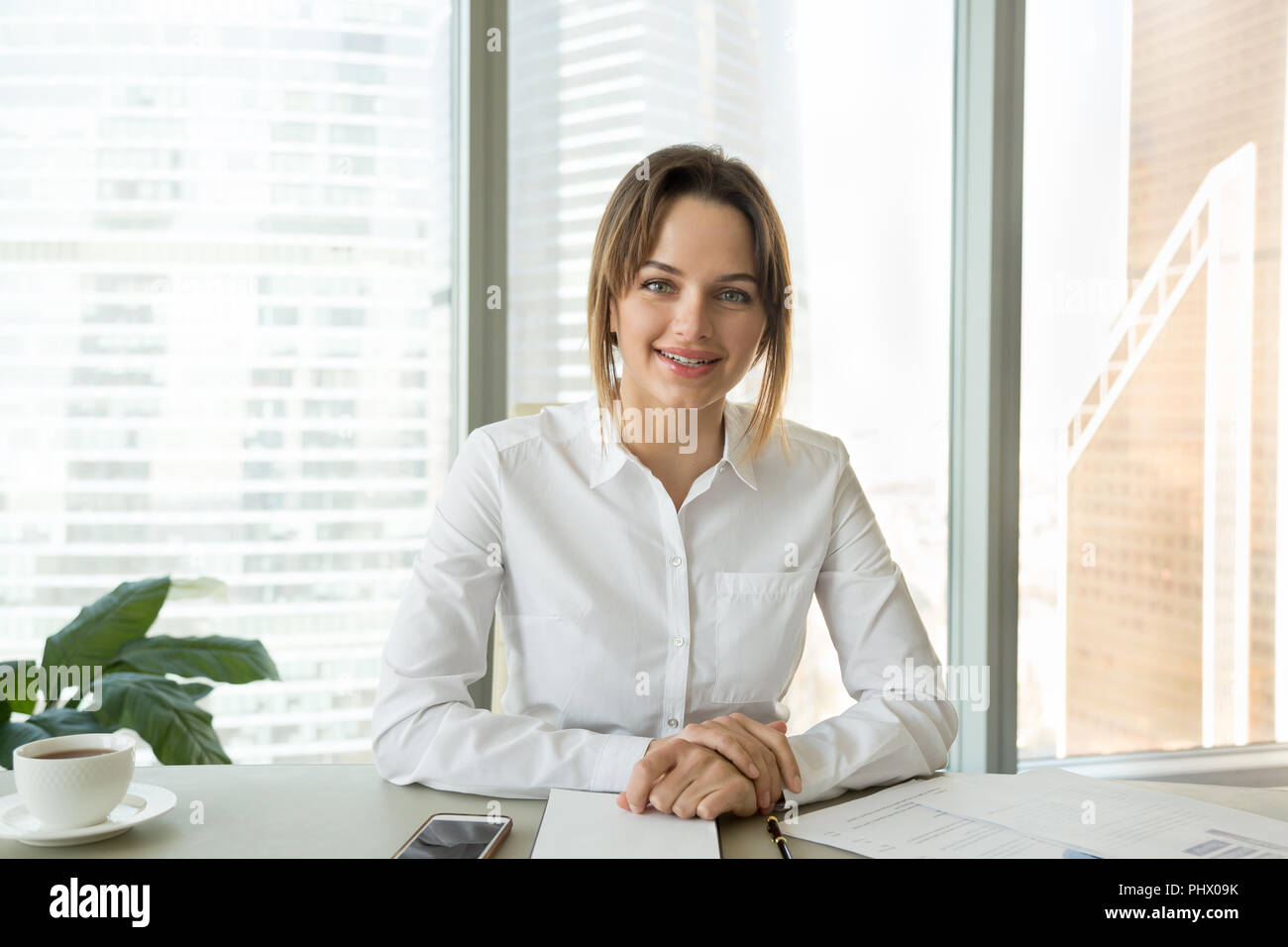 Successful businesswoman talking at camera giving interview or r Stock Photo