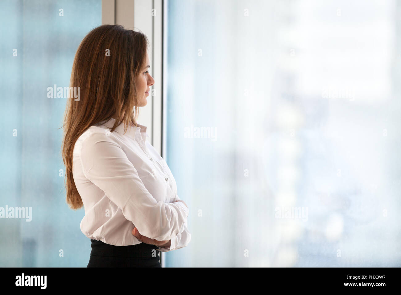 Successful thoughtful woman business leader looking out of big w Stock Photo