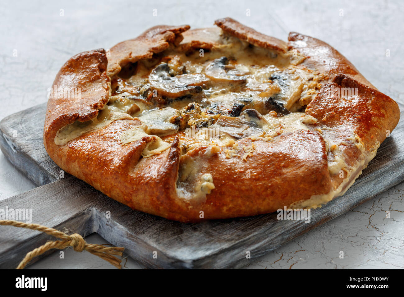 Free-form pie with mushrooms, onions and blue cheese. Stock Photo