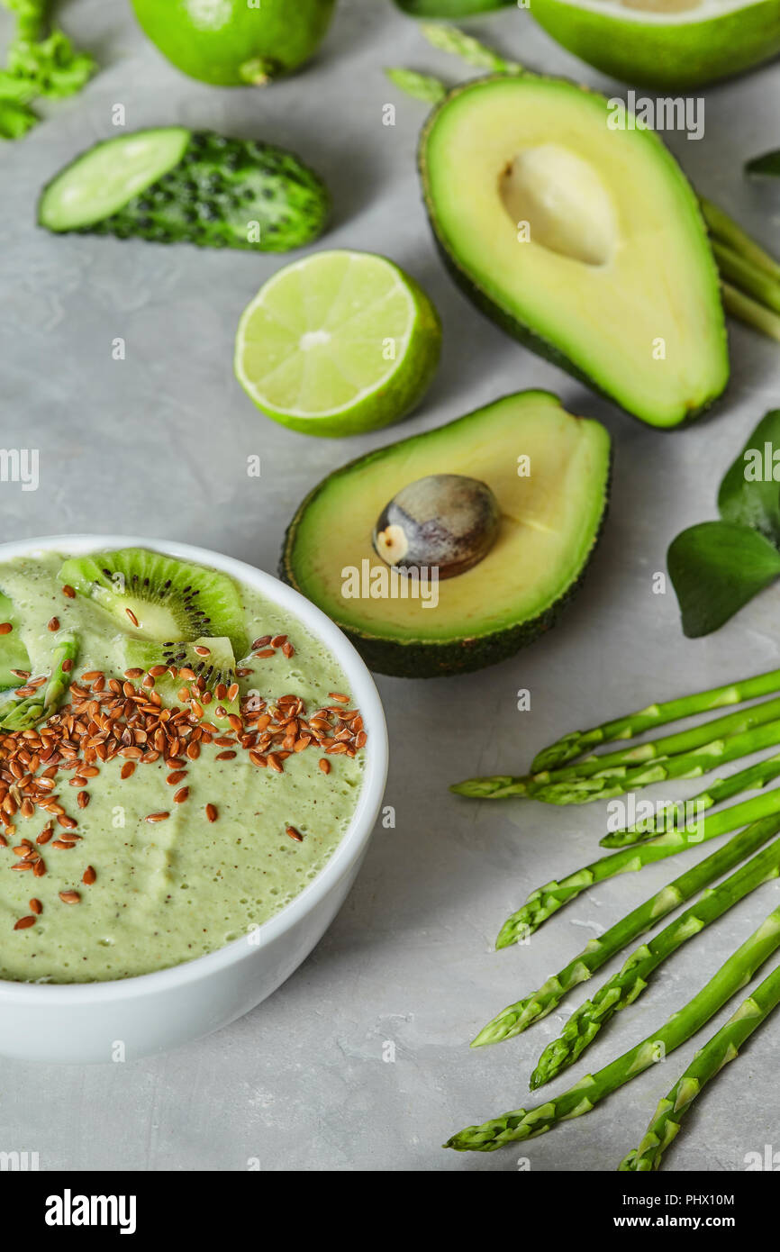 Green smoothie bowl on a light grey slate concrete background. Stock Photo