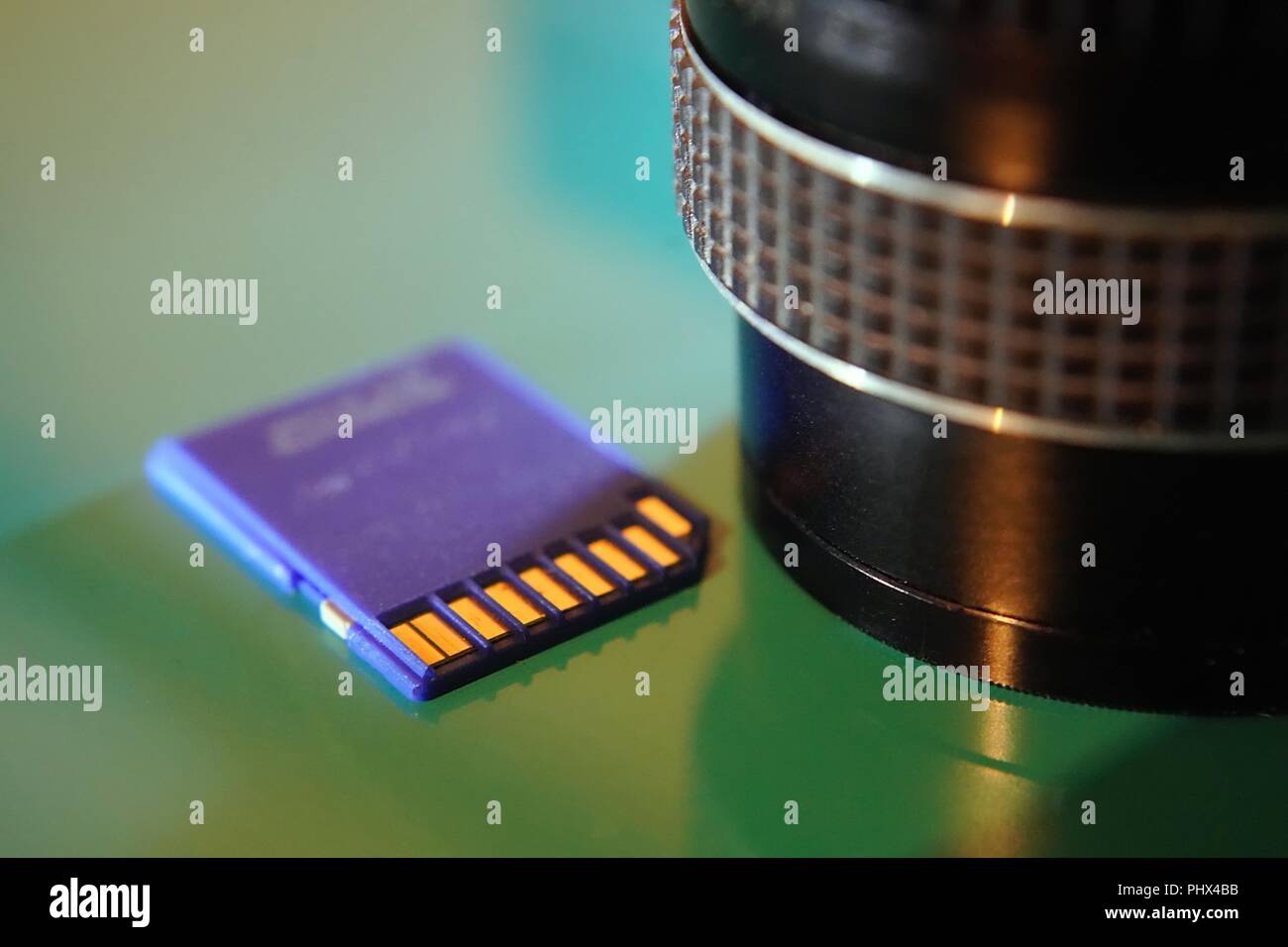 Multimedia SD Card and camera lens close up Stock Photo