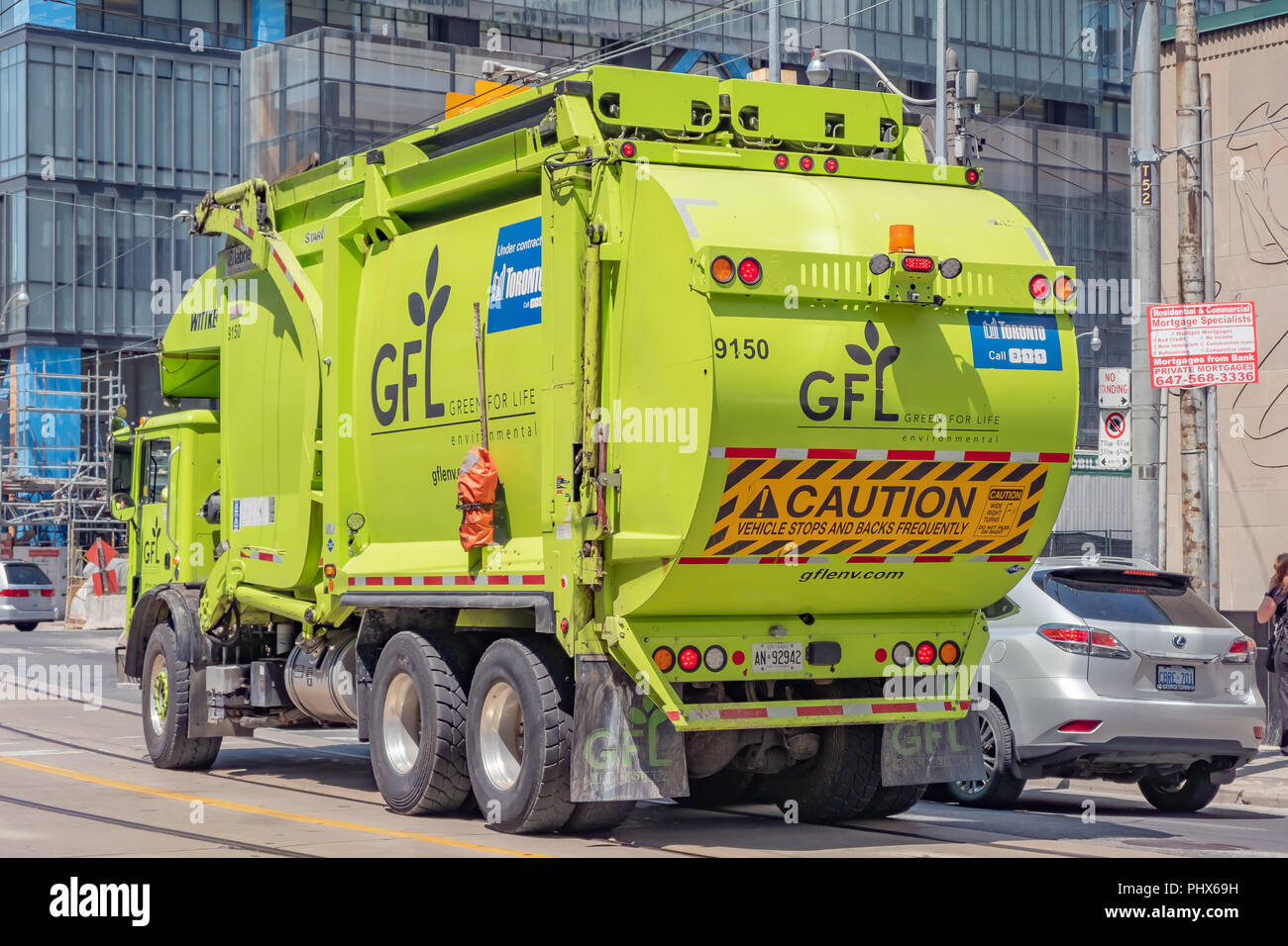 A green organic waste management truck driving in downtown Toronto Ontario Canada. Stock Photo