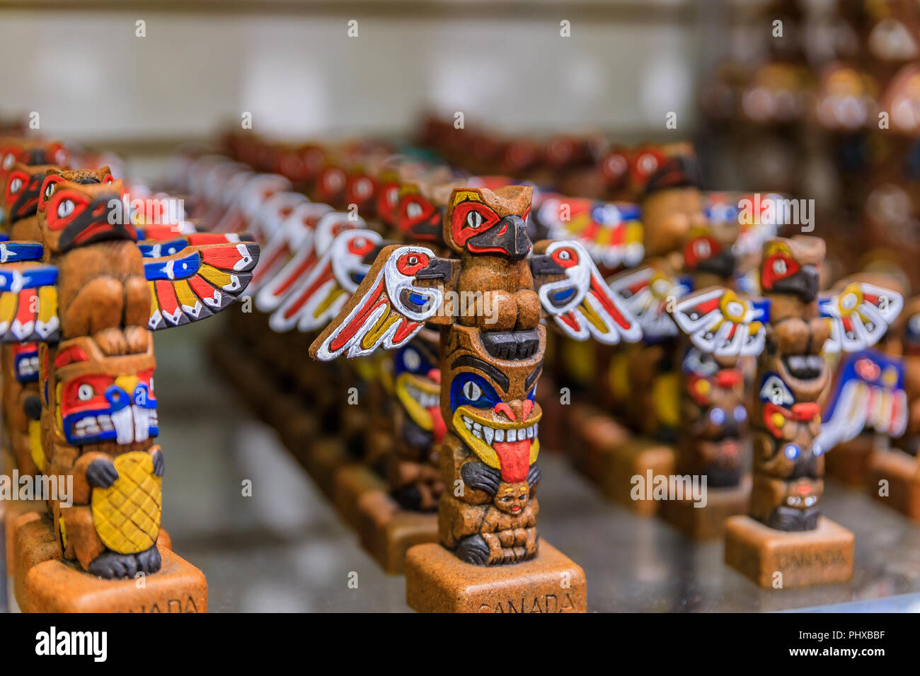 Carved wooden miniature First Nations or Native American Indian totem pole souvenirs at a tourist shop in Vancouver Canada Stock Photo