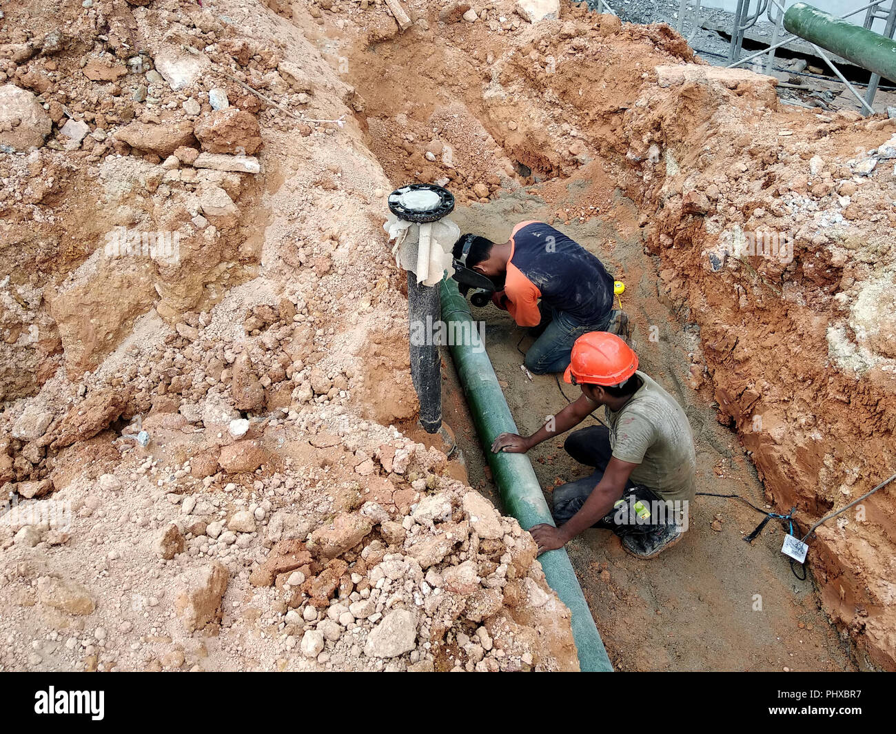 Underground utility and services pipe laid by workers in the trenches