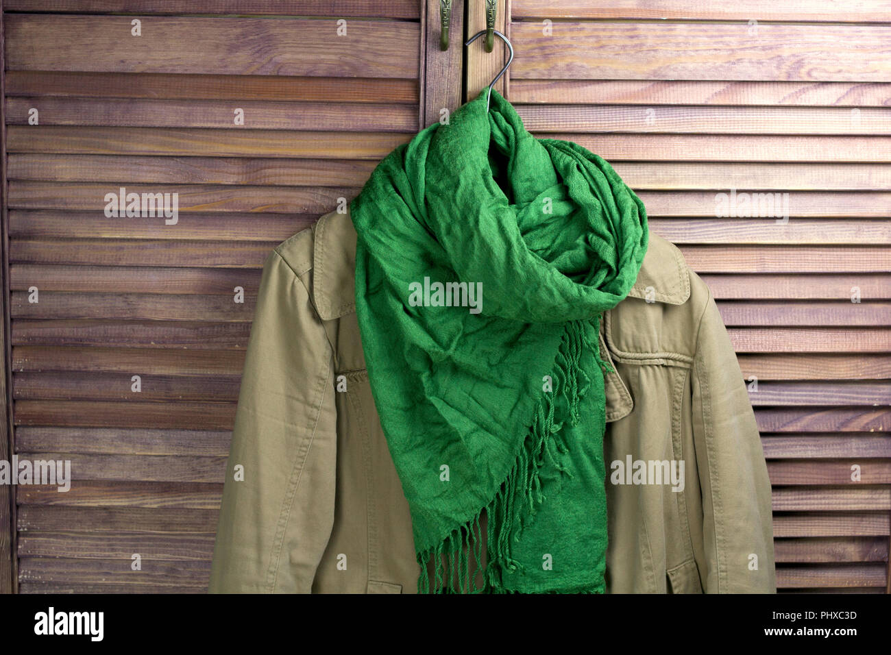coat with scarf on the hanger, vintage closet for the background Stock Photo