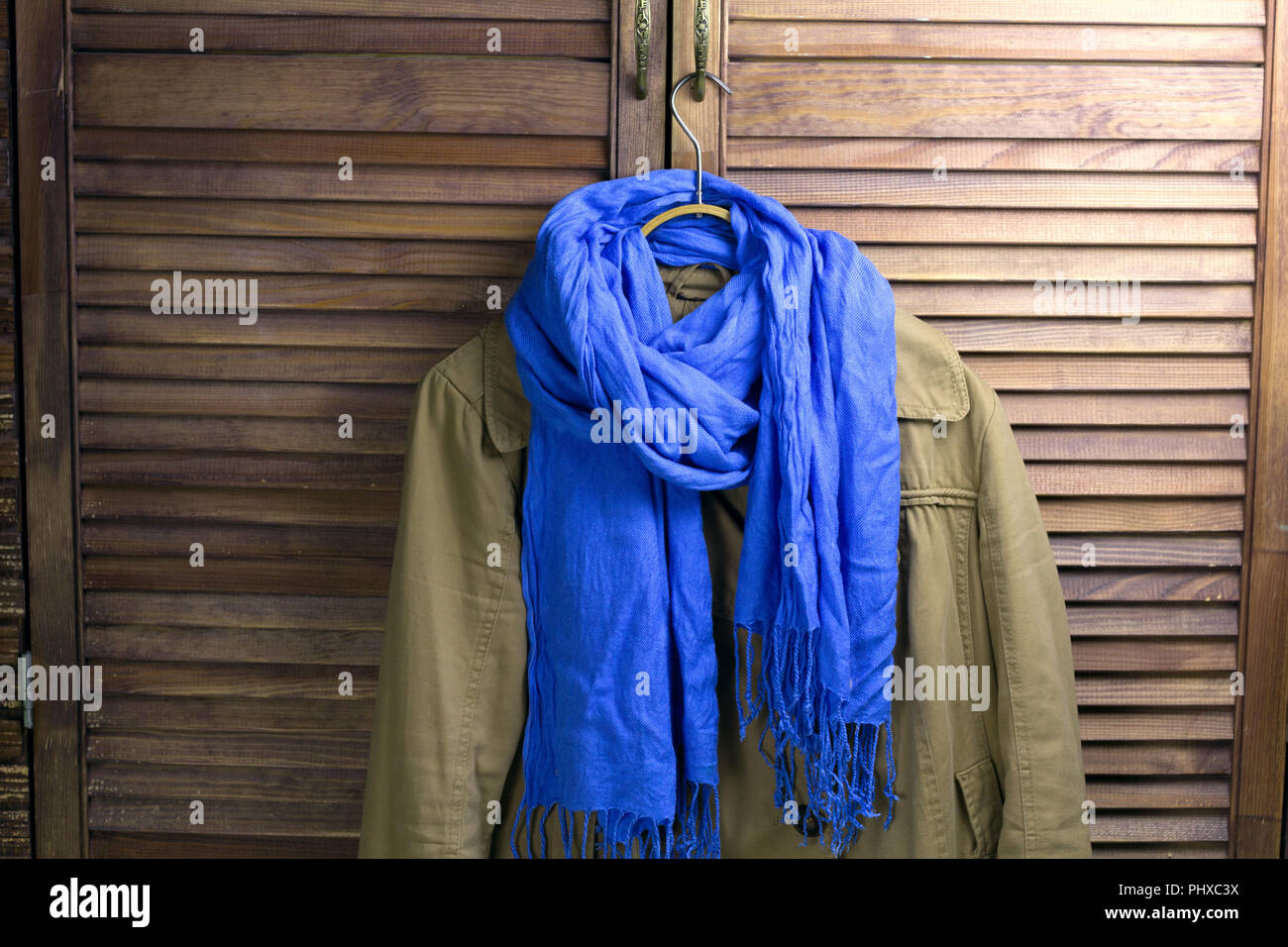 coat with scarf on the hanger, vintage closet for the background Stock Photo