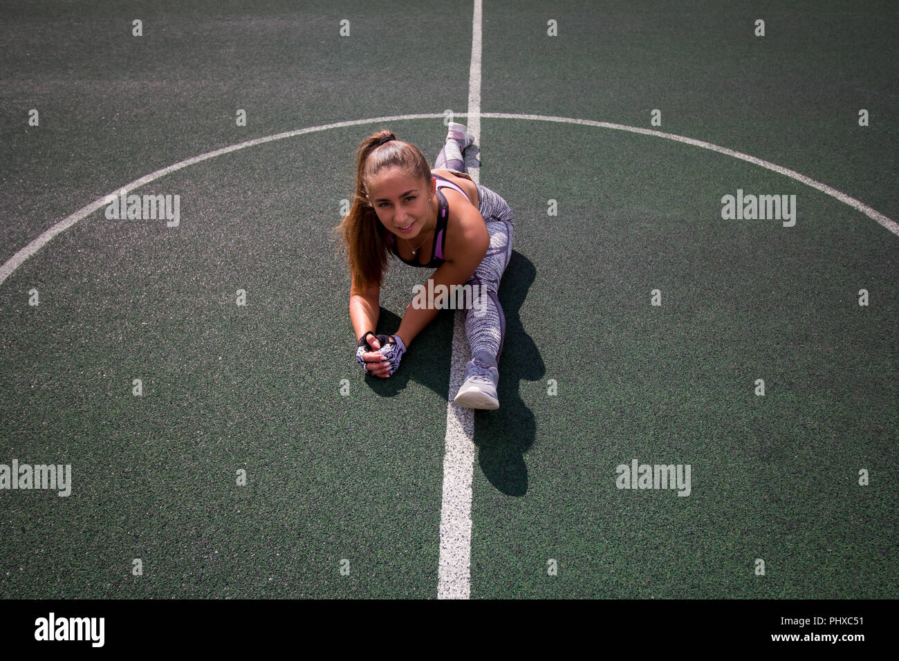beautiful young athletic girl doing stretching outdoor on the basketball court, sports,  healthy lifestyle concept Stock Photo