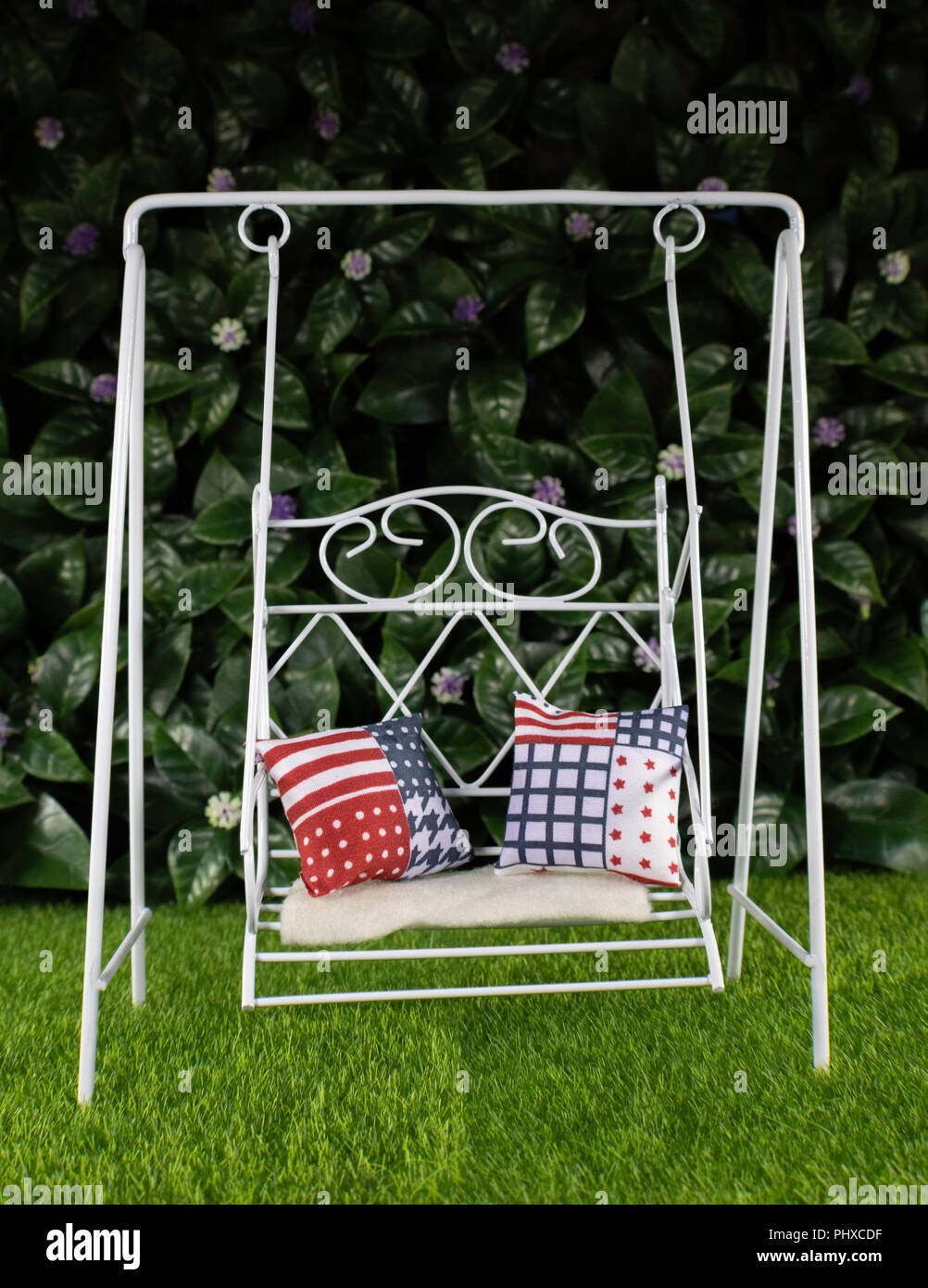 Handmade white metal love swing with a pair of cushions in the garden. Studio  backdrop Stock Photo - Alamy