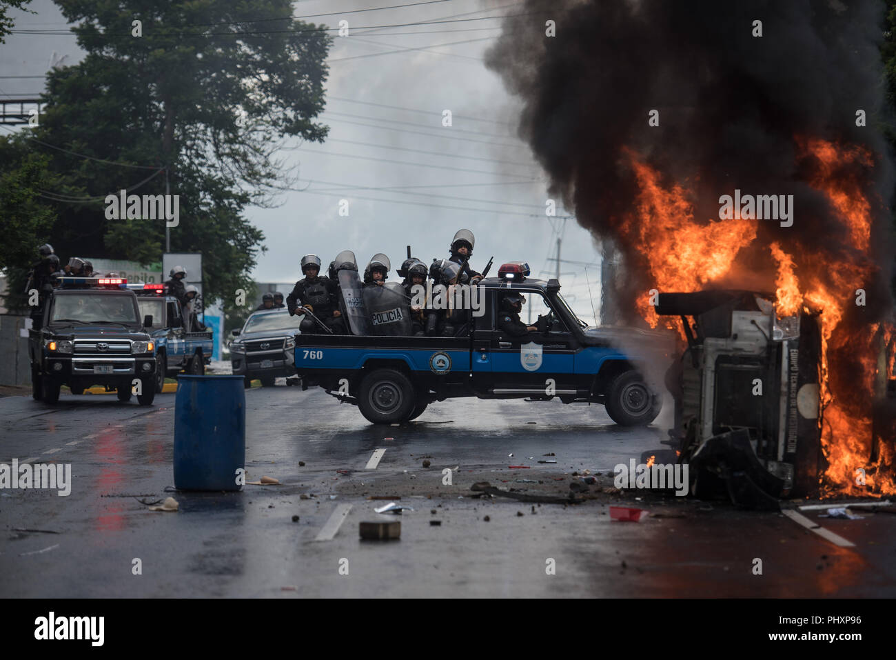 Managua, Nicaragua. 02nd Sep, 2018. 02.09.2018, Nicaragua, Managua: Heavily armed police officers sit on a pick-up and stand next to a burning police car. At least one person was injured in Managua when strangers fired guns at participants in a demonstration against the government. Credit: Carlos Herrera/dpa/Alamy Live News Stock Photo
