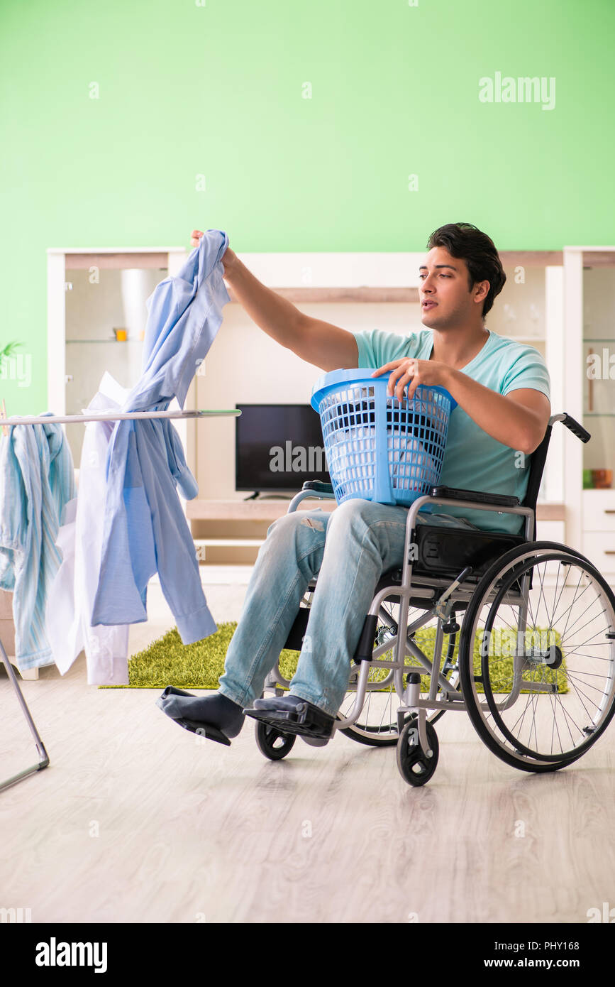 Disabled man on wheelchair doing laundry Stock Photo