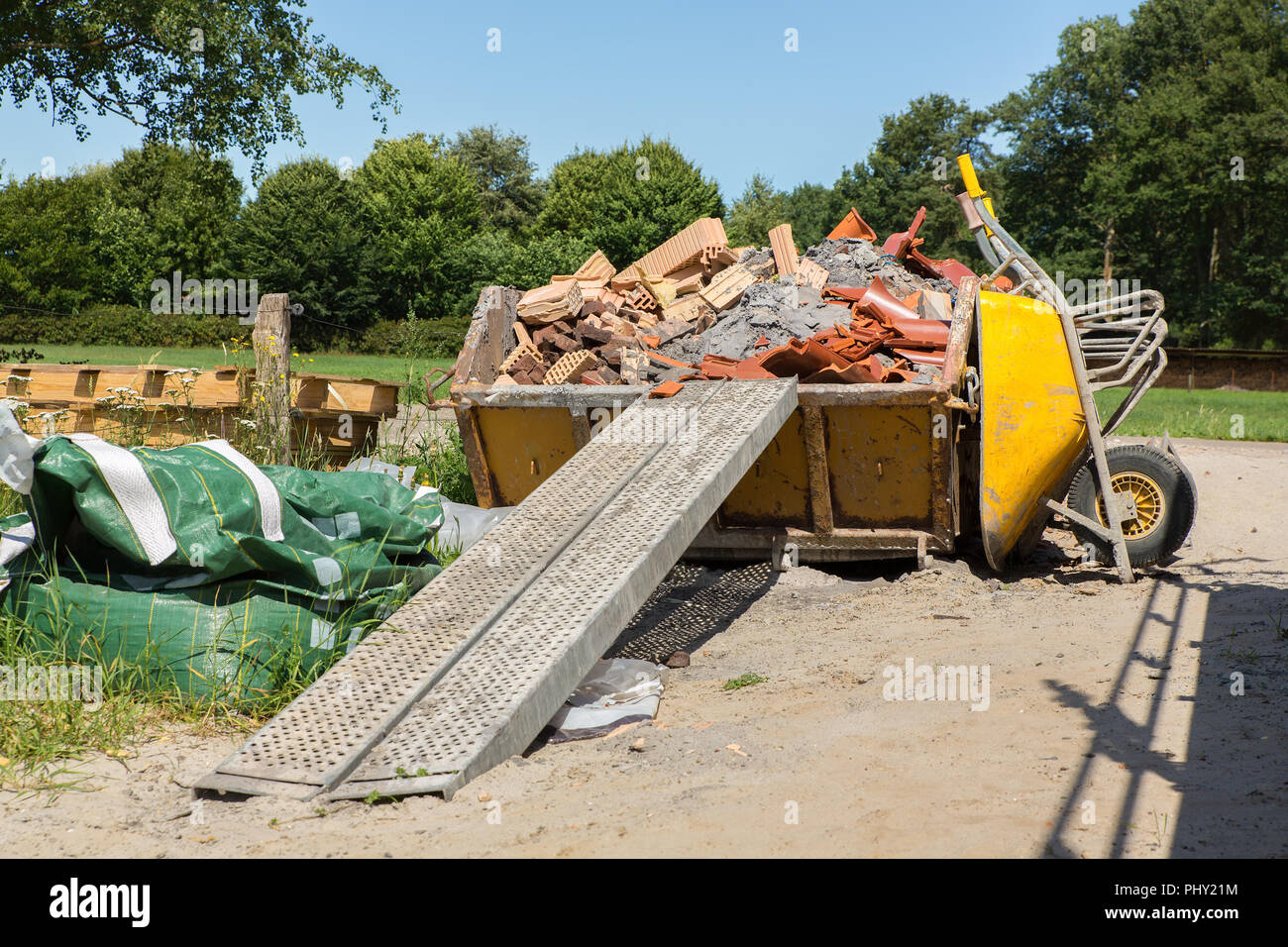 Container with debris and wheelbarrow in the netherlands Stock Photo
