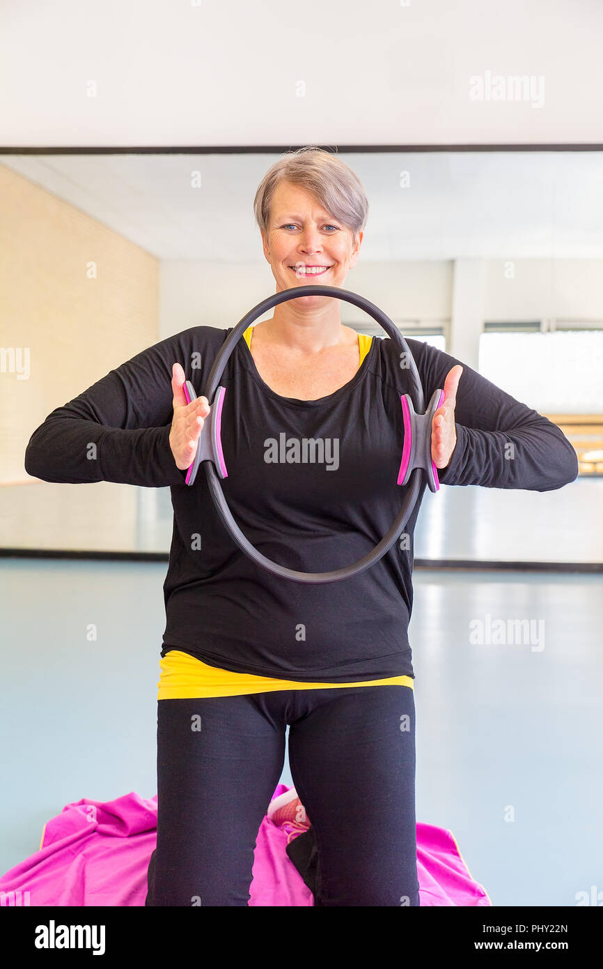 Sportswoman demonstrates exercise in gym Stock Photo
