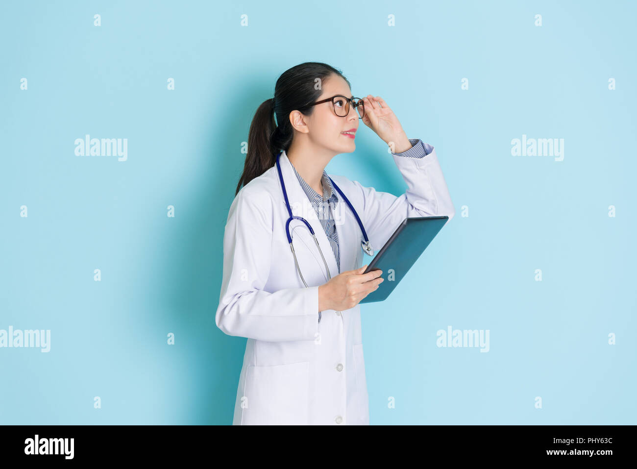 female intern medical student holding her tablet and looking happily with a smile. Stock Photo