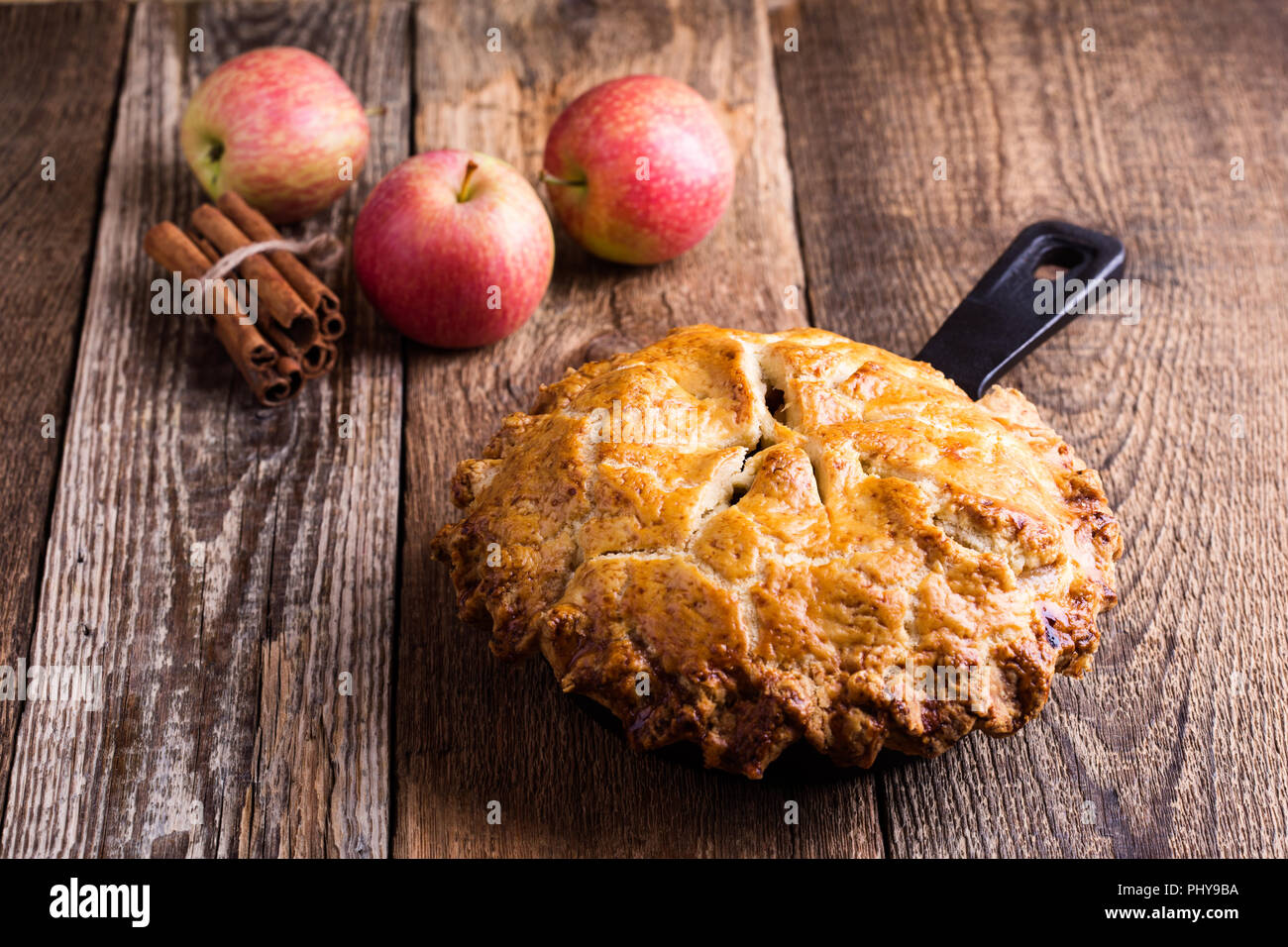 https://c8.alamy.com/comp/PHY9BA/apple-pie-in-cast-iron-skillet-on-rustic-wooden-table-traditional-autumn-cozy-dessert-PHY9BA.jpg