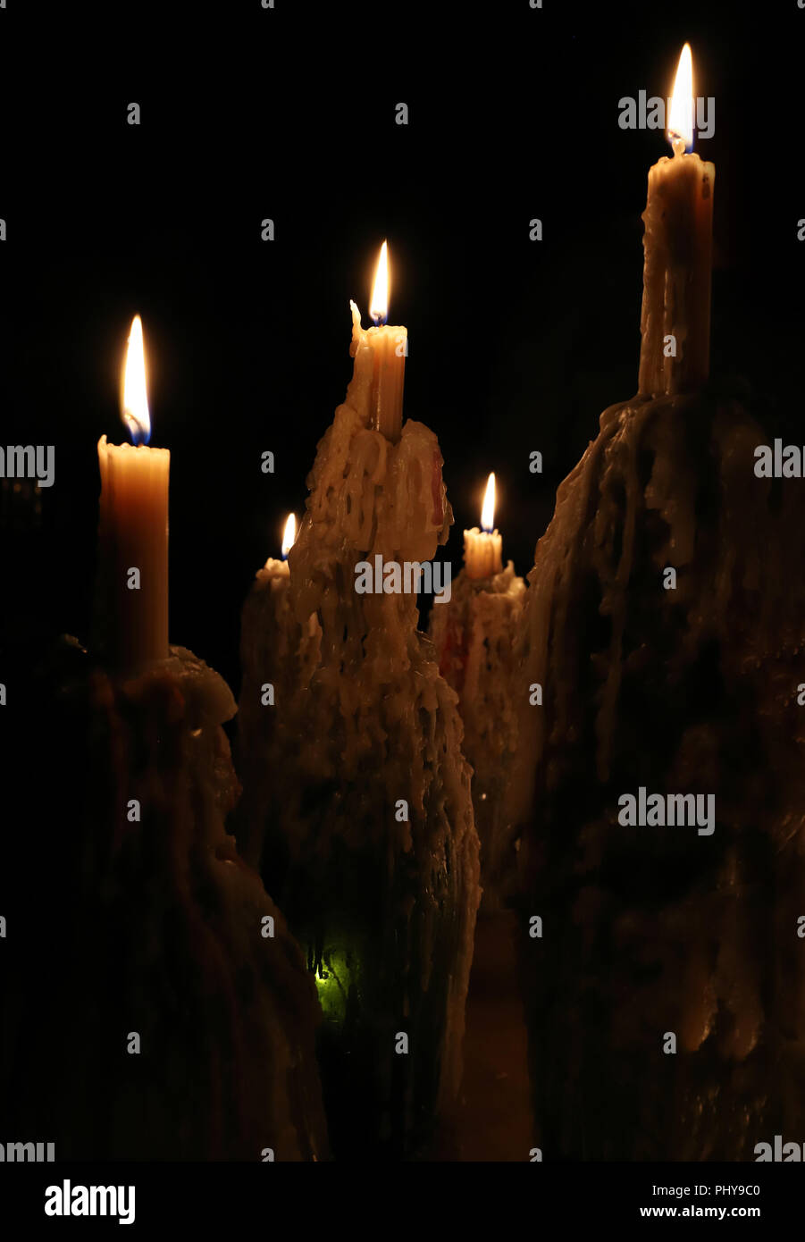 Burning candles in the dark, melted candle wax, candle flame. Christmas