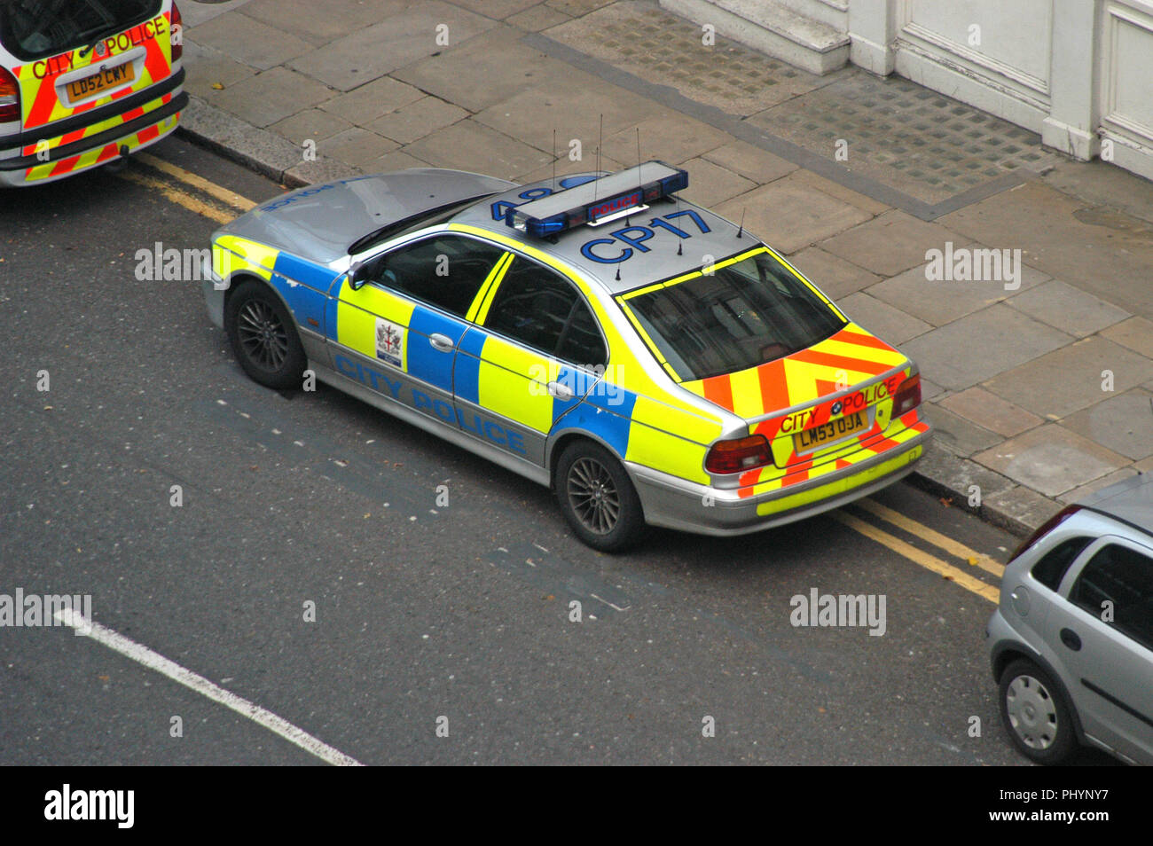 rear view High visibility markings on a British Police car with number on roof parked on street outside police station as seen from high up in London Stock Photo