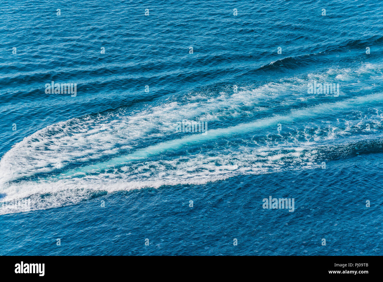 Trail on water surface behind of fast moving motor boat Stock Photo - Alamy