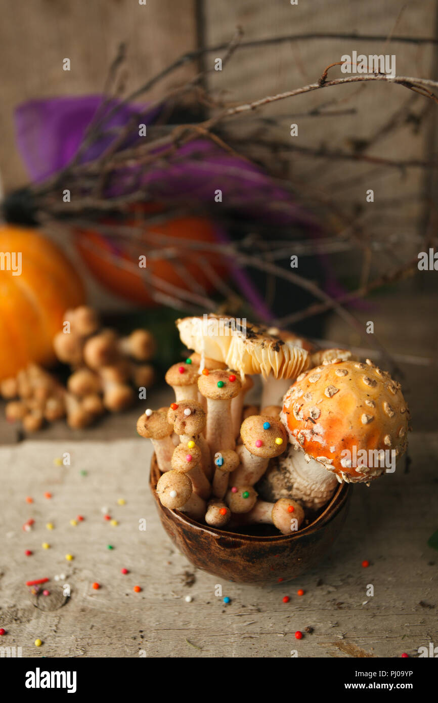 Woods, fairy tales & mysterious creature concept - poisonus mushrooms in the cup with confectionary decor on wooden table, magic, fantastic food Stock Photo