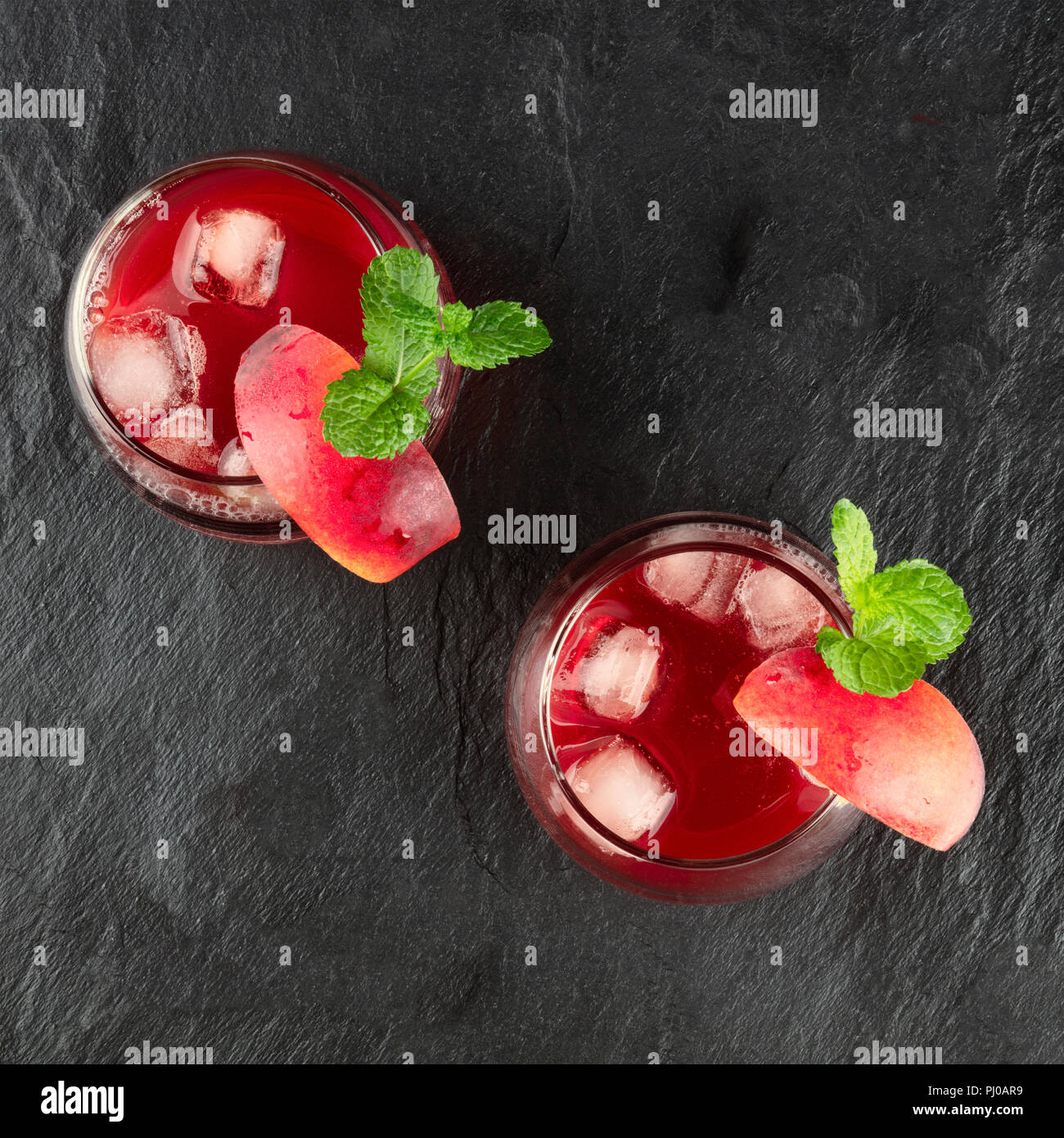 Overhead photo of vibrant red drinks with mint on black Stock Photo