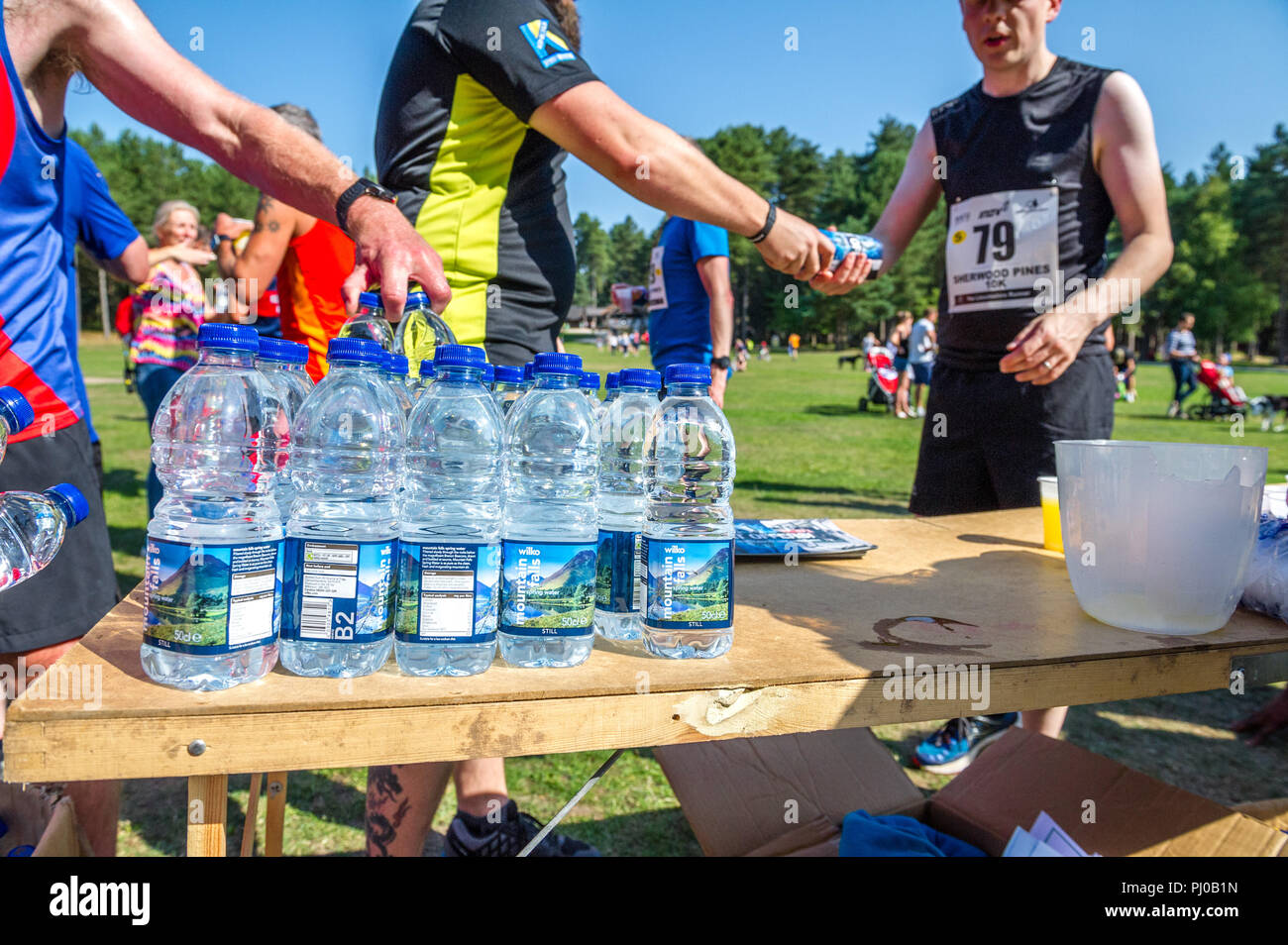Plastic bottled water being handed out to runners at the finish on the 2018 Sherwood Pines 10k. Stock Photo