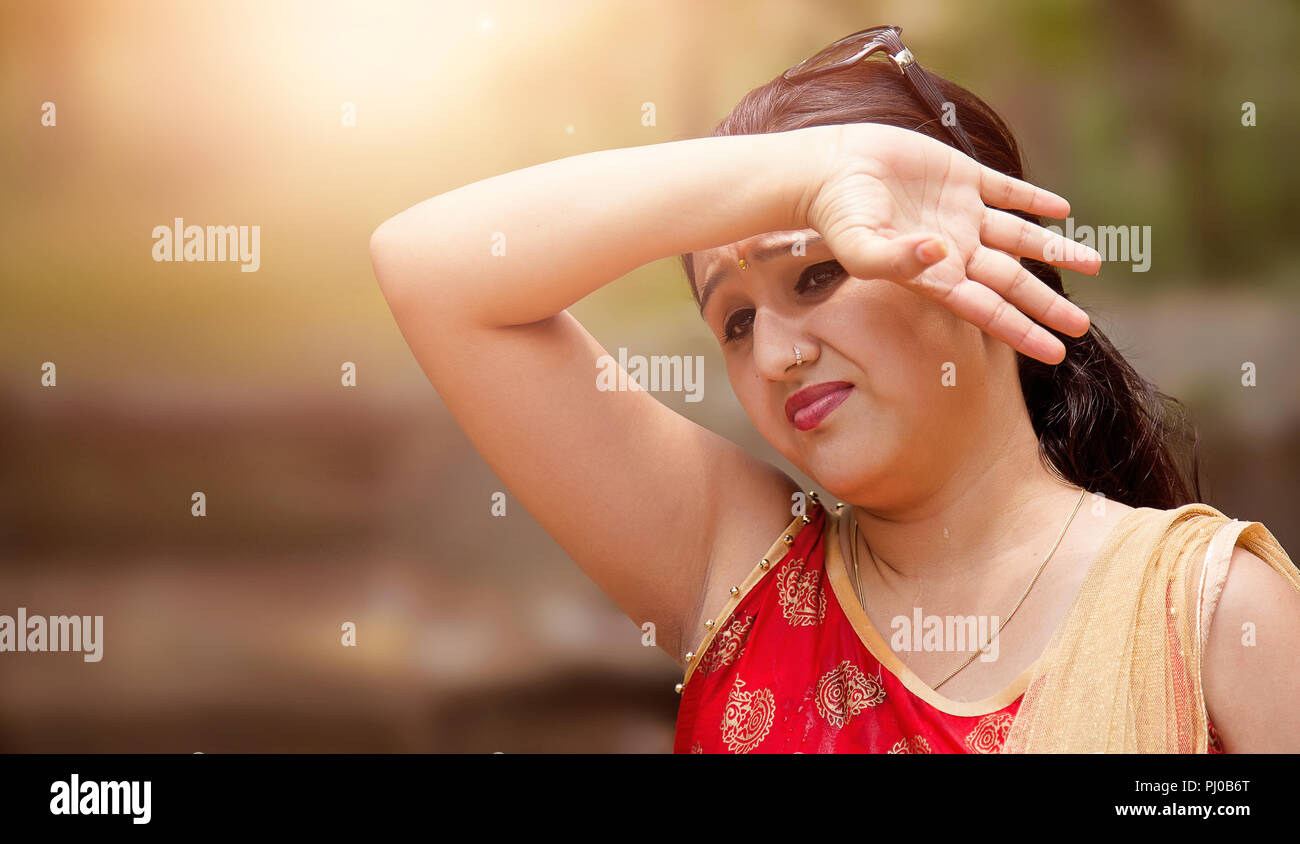 Woman shielding her eyes from sun. Stock Photo