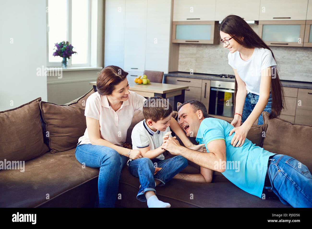 The family plays together fun on the couch. Stock Photo