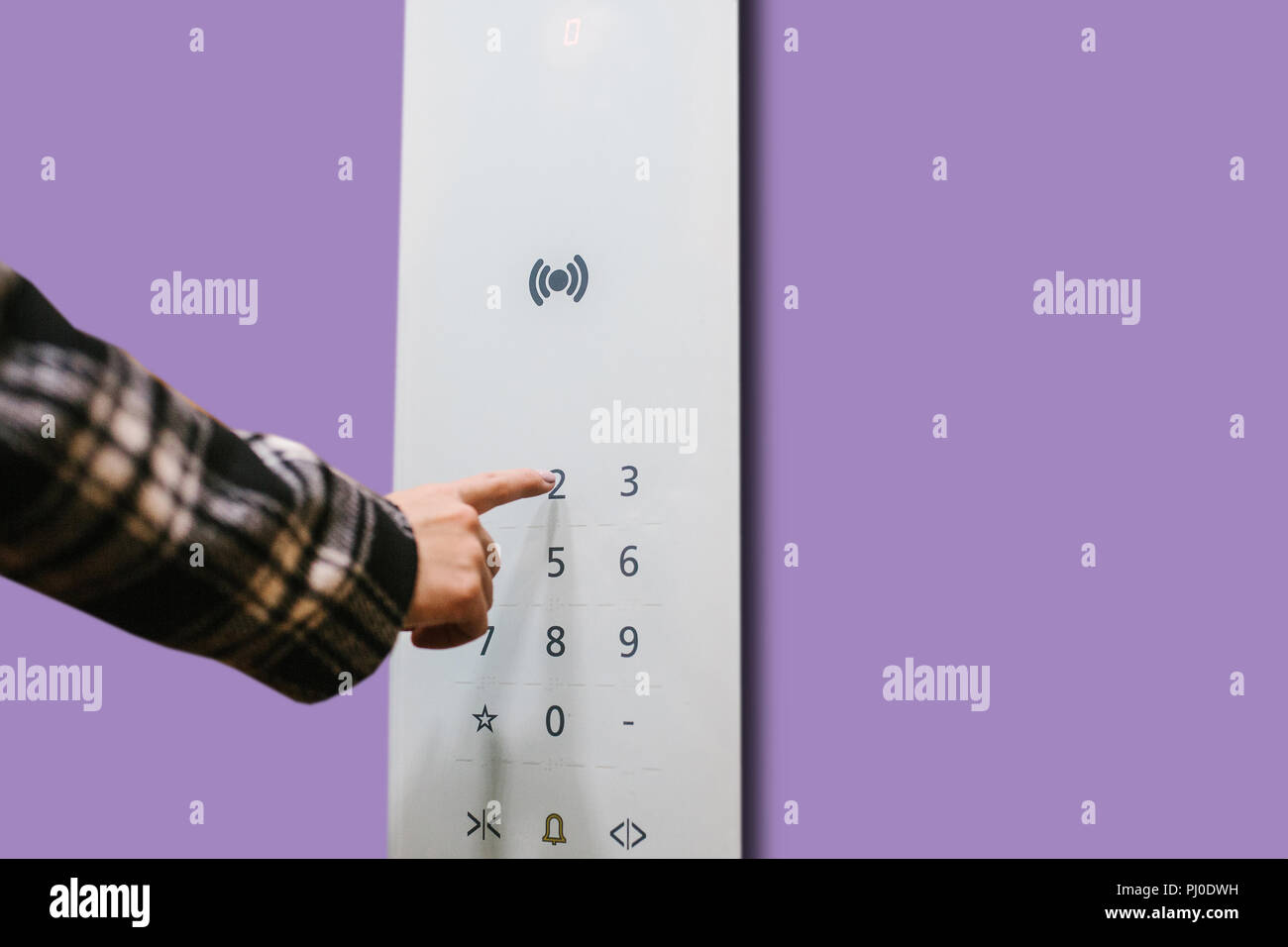 Close-up of a girl pressing a touch button in a modern elevator. Stock Photo