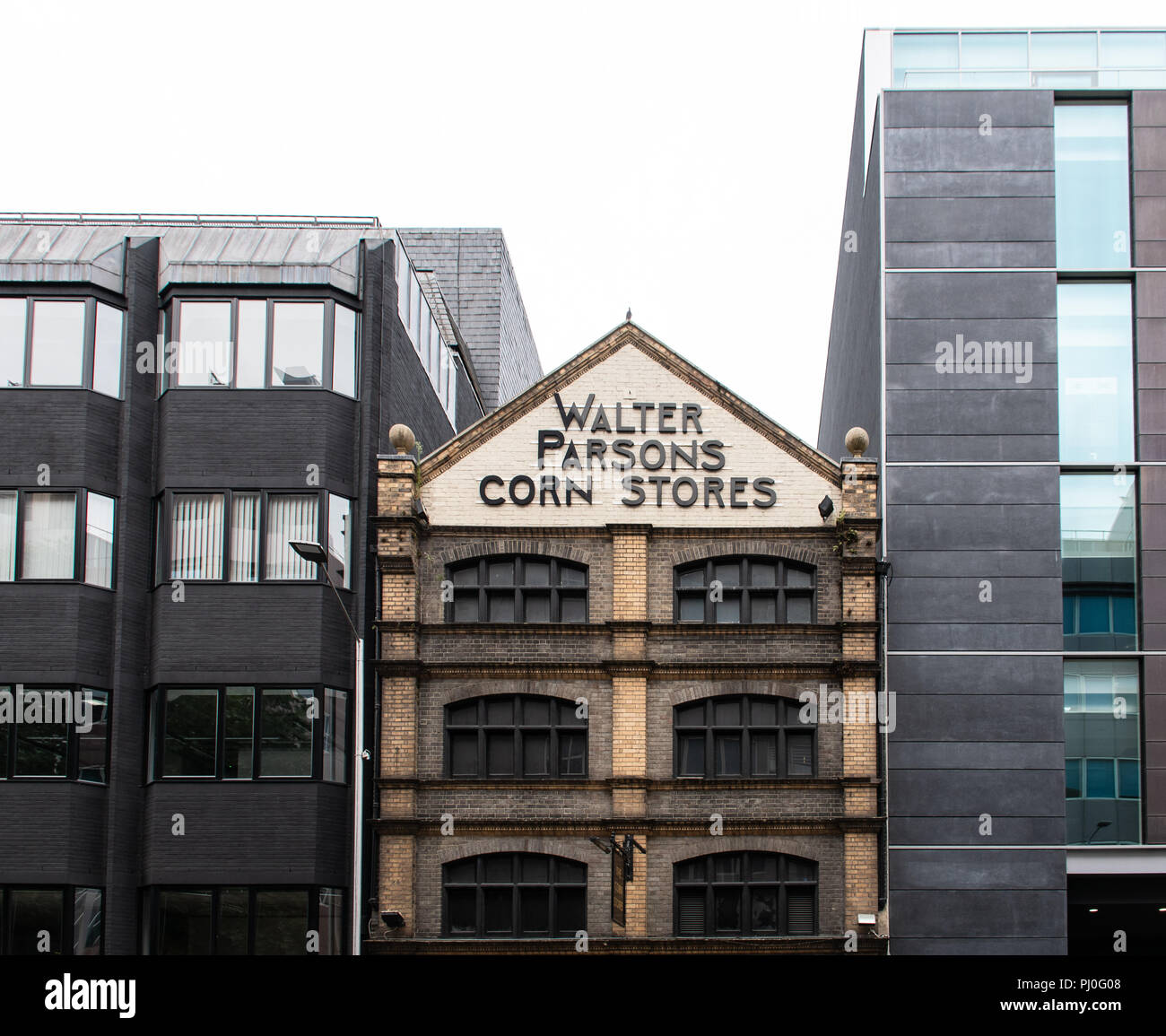 Reading, United Kingdom - August 22 2018:   The old Corn Stores pub nestles between two modern office blocks on Forbury Road Stock Photo