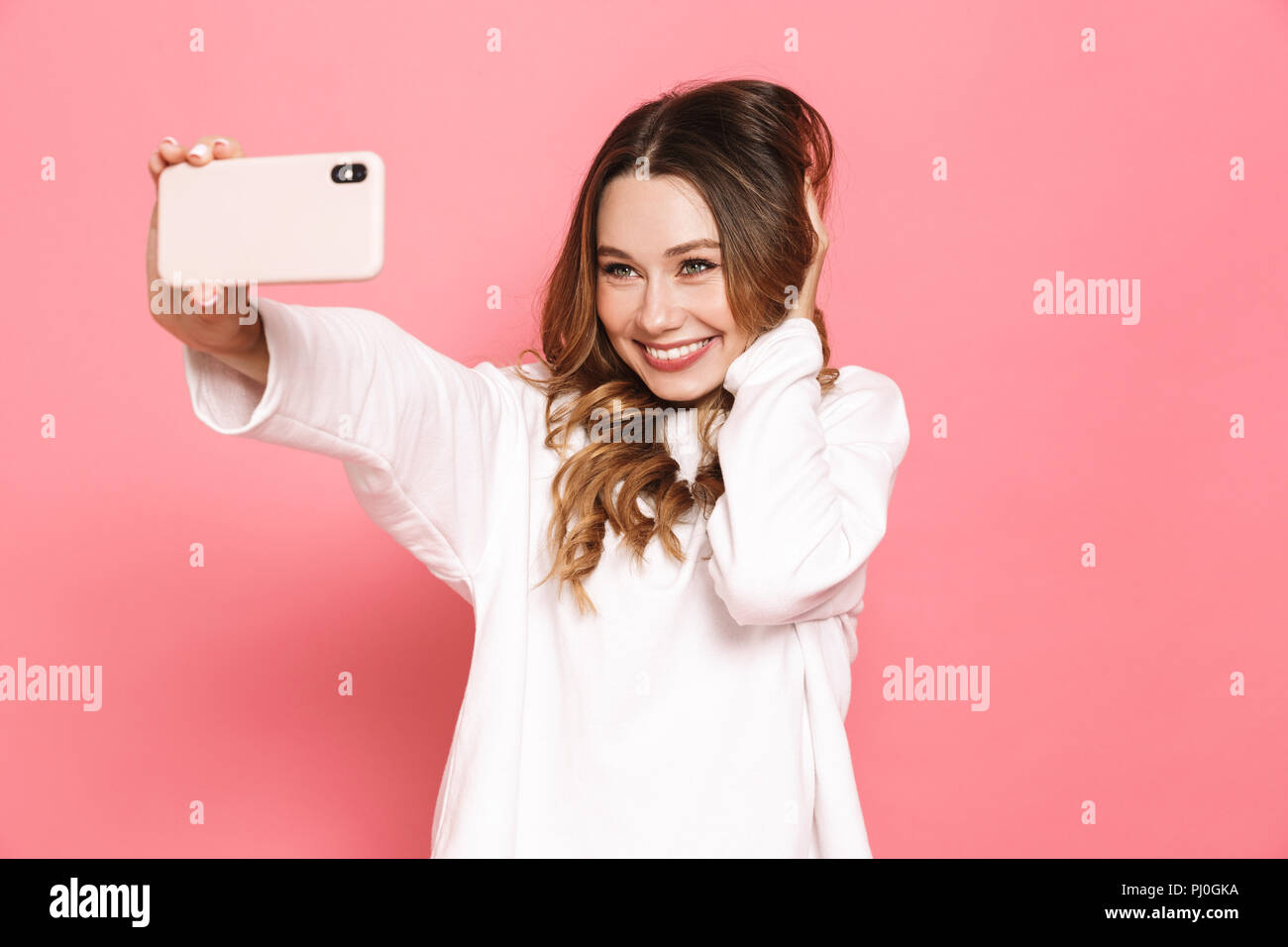 Portrait of a pretty young woman taking selfie with mobile phone ...