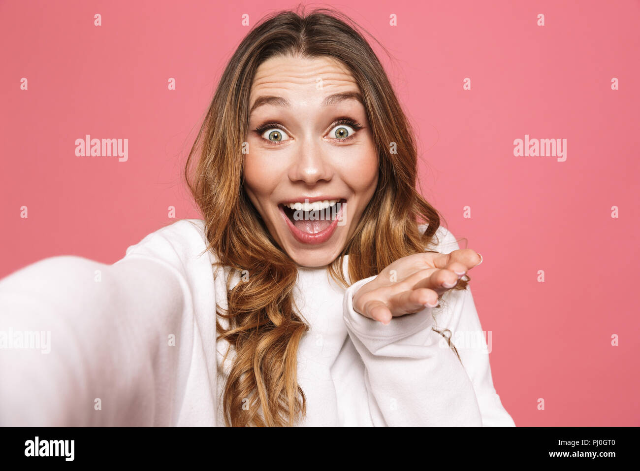 Portrait Of A Joyful Young Woman Taking Selfie With Outstretched Hand