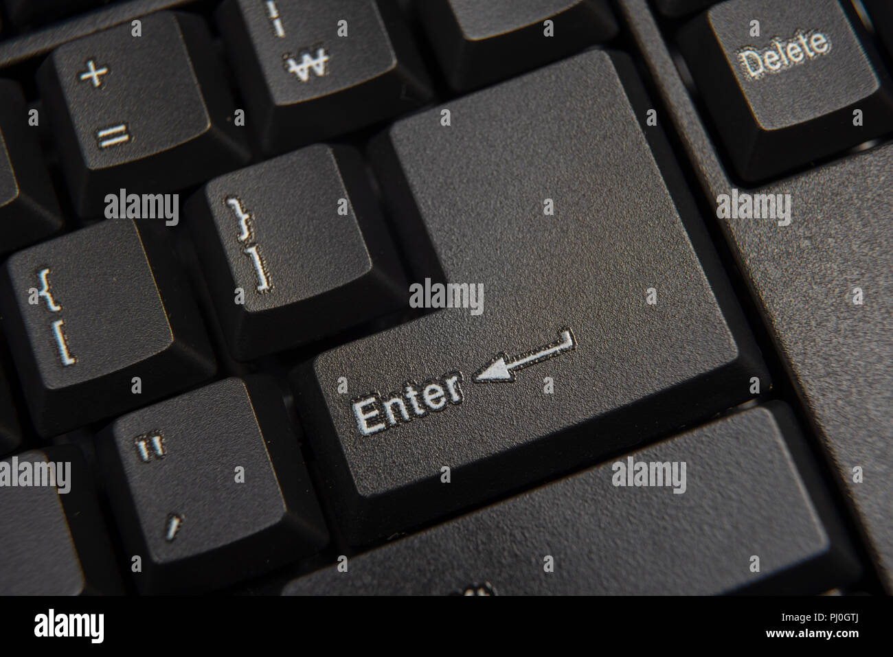 Black computer keyboard close-up. Focused on 'Enter' key. Stock Photo